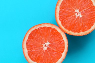 Mavi renkte parlak arka plan üzerinde üstten görünüm birkaç greyfurt dilim. Doymuş narenciye doku görüntü
