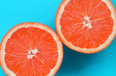 Mavi renkte parlak arka plan üzerinde üstten görünüm birkaç greyfurt dilim. Doymuş narenciye doku görüntü