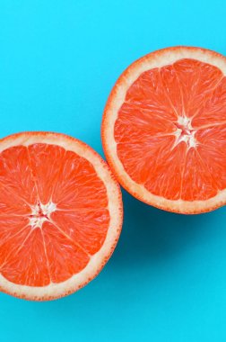Mavi renkte parlak arka plan üzerinde üstten görünüm birkaç greyfurt dilim. Doymuş narenciye doku görüntü