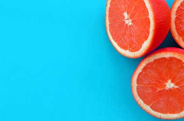 Mavi renkte parlak arka plan üzerinde üstten görünüm birkaç greyfurt dilim. Doymuş narenciye doku görüntü