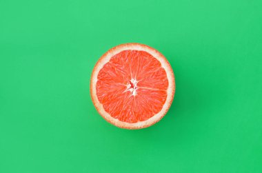 Yeşil renkli parlak arka plan üzerinde üstten görünüm bir greyfurt dilim. Doymuş narenciye doku görüntü