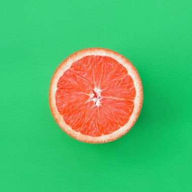 Yeşil renkli parlak arka plan üzerinde üstten görünüm bir greyfurt dilim. Doymuş narenciye doku görüntü