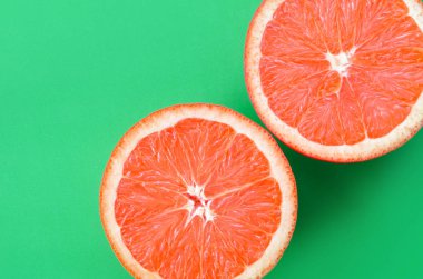 Yeşil renkli parlak arka plan üzerinde üstten görünüm birkaç greyfurt dilim. Doymuş narenciye doku görüntü