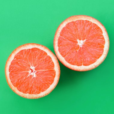Yeşil renkli parlak arka plan üzerinde üstten görünüm birkaç greyfurt dilim. Doymuş narenciye doku görüntü