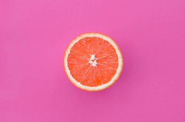 Mor renkli parlak arka plan üzerinde üstten görünüm bir greyfurt dilim. Doymuş narenciye doku görüntü