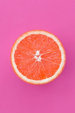 Mor renkli parlak arka plan üzerinde üstten görünüm bir greyfurt dilim. Doymuş narenciye doku görüntü