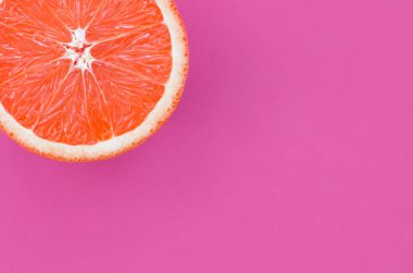 Mor renkli parlak arka plan üzerinde üstten görünüm bir greyfurt dilim. Doymuş narenciye doku görüntü