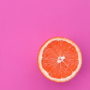 Mor renkli parlak arka plan üzerinde üstten görünüm bir greyfurt dilim. Doymuş narenciye doku görüntü