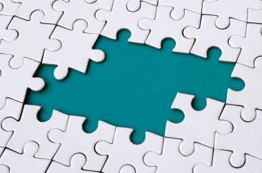 Beyaz jigsaw bulmaca monte durumunda eksik öğeleri metin için mavi bir ped şekillendirme ile yakın çekim doku. Kopya alanı