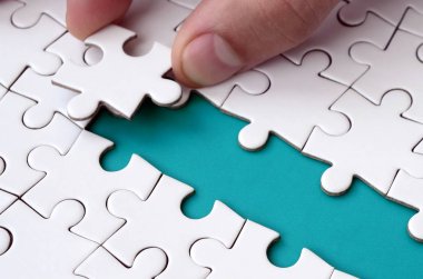 İnsan eli jigsaw bulmaca, mavi bir alan oluşturan yüzeye yol açıyor. Başarı için yolda zorluklar üstesinden kavramı