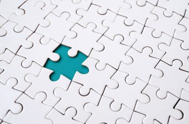 Beyaz jigsaw bulmaca monte durumunda eksik öğeleri metin için mavi bir ped şekillendirme ile yakın çekim doku. Kopya alanı