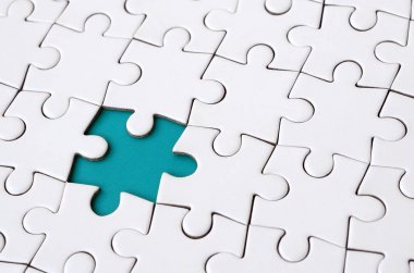 Beyaz jigsaw bulmaca monte durumunda eksik öğeleri metin için mavi bir ped şekillendirme ile yakın çekim doku. Kopya alanı