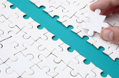 İnsan eli jigsaw bulmaca, mavi bir alan oluşturan yüzeye yol açıyor. Başarı için yolda zorluklar üstesinden kavramı