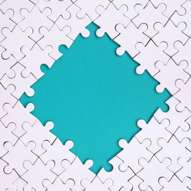 Beyaz jigsaw bulmaca mavi alanı çevresinde yapılan bir rhombus şeklinde çerçeveleme