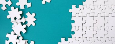 Katlanmış bir beyaz jigsaw puzzle ve bir yığın uncombed bulmaca öğeleri arka planı mavi bir yüzey parçası. Metin için yer ile doku fotoğraf