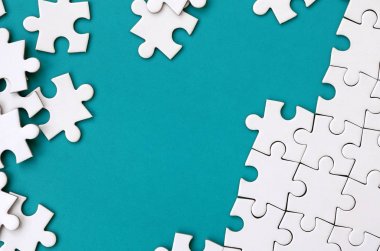 Katlanmış bir beyaz jigsaw puzzle ve bir yığın uncombed bulmaca öğeleri arka planı mavi bir yüzey parçası. Metin için yer ile doku fotoğraf