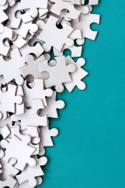 Bir yığın beyaz jigsaw puzzle uncombed unsurlarının mavi bir yüzey arka plan üzerinde yatıyor. Metin kopyalama yeri olan doku fotoğraf