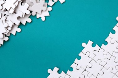 Katlanmış bir beyaz jigsaw puzzle ve bir yığın uncombed bulmaca öğeleri arka planı mavi bir yüzey parçası. Metin için yer ile doku fotoğraf