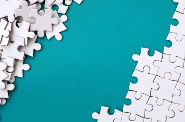 Katlanmış bir beyaz jigsaw puzzle ve bir yığın uncombed bulmaca öğeleri arka planı mavi bir yüzey parçası. Metin için yer ile doku fotoğraf