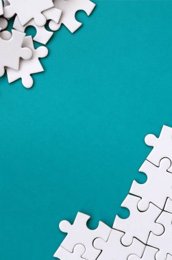 Katlanmış bir beyaz jigsaw puzzle ve bir yığın uncombed bulmaca öğeleri arka planı mavi bir yüzey parçası. Metin için yer ile doku fotoğraf