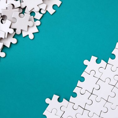 Katlanmış bir beyaz jigsaw puzzle ve bir yığın uncombed bulmaca öğeleri arka planı mavi bir yüzey parçası. Metin için yer ile doku fotoğraf