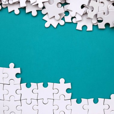 Katlanmış bir beyaz jigsaw puzzle ve bir yığın uncombed bulmaca öğeleri arka planı mavi bir yüzey parçası. Metin için yer ile doku fotoğraf