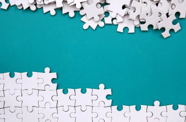 Katlanmış bir beyaz jigsaw puzzle ve bir yığın uncombed bulmaca öğeleri arka planı mavi bir yüzey parçası. Metin için yer ile doku fotoğraf
