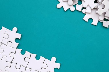 Katlanmış bir beyaz jigsaw puzzle ve bir yığın uncombed bulmaca öğeleri arka planı mavi bir yüzey parçası. Metin için yer ile doku fotoğraf