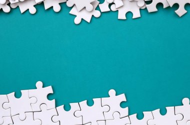 Katlanmış bir beyaz jigsaw puzzle ve bir yığın uncombed bulmaca öğeleri arka planı mavi bir yüzey parçası. Metin için yer ile doku fotoğraf