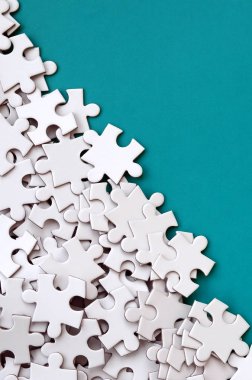 Bir yığın beyaz jigsaw puzzle uncombed unsurlarının mavi bir yüzey arka plan üzerinde yatıyor. Metin kopyalama yeri olan doku fotoğraf