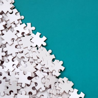 Bir yığın beyaz jigsaw puzzle uncombed unsurlarının mavi bir yüzey arka plan üzerinde yatıyor. Metin kopyalama yeri olan doku fotoğraf