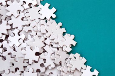 Bir yığın beyaz jigsaw puzzle uncombed unsurlarının mavi bir yüzey arka plan üzerinde yatıyor. Metin kopyalama yeri olan doku fotoğraf