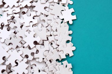 Bir yığın beyaz jigsaw puzzle uncombed unsurlarının mavi bir yüzey arka plan üzerinde yatıyor. Metin kopyalama yeri olan doku fotoğraf