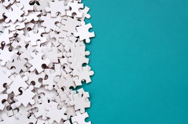 Bir yığın beyaz jigsaw puzzle uncombed unsurlarının mavi bir yüzey arka plan üzerinde yatıyor. Metin kopyalama yeri olan doku fotoğraf