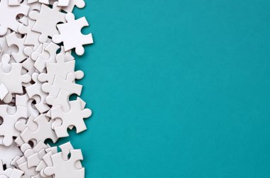 Bir yığın beyaz jigsaw puzzle uncombed unsurlarının mavi bir yüzey arka plan üzerinde yatıyor. Metin kopyalama yeri olan doku fotoğraf