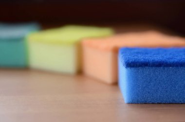 Birkaç mutfak süngerler yalan Ahşap mutfak tezgah üzerine. Bulaşıkları yıkama ve temizlik için renkli nesneleri kullanıma hazır