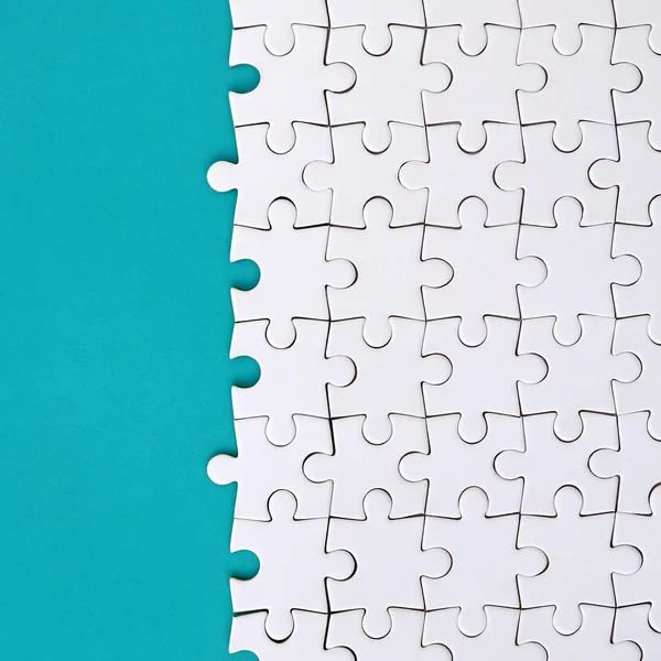 Frammento Puzzle Bianco Piegato Sullo Sfondo Una Superficie Plastica Blu — Foto Stock