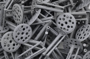 Background pattern of many gray plastic dowels fastening for thermal insulation. A huge pile of fixtures for the installation of expanded polystyrene plates for the insulation of the building walls clipart