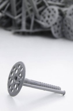 Bir gri plastik dübel yuvarlak Şemsiye kapakları ısı yalıtımı için tespitleme Gri köpük polistiren tabakta yatıyor