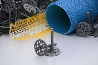 Duvar yalıtım inşaat öğeleri kümesi. Plastik dübeller, bir rulo kafes cepheler ve köşe profili bir kılavuz ile yalıtım için yalan polistren köpük yüzeyinde