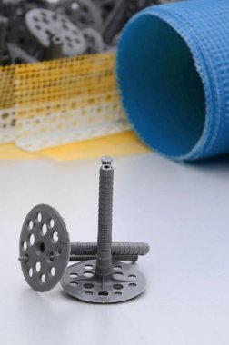 Duvar yalıtım inşaat öğeleri kümesi. Plastik dübeller, bir rulo kafes cepheler ve köşe profili bir kılavuz ile yalıtım için yalan polistren köpük yüzeyinde