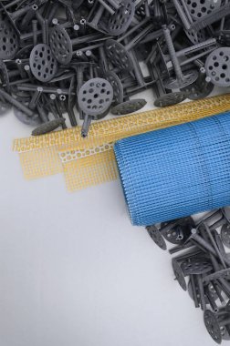 Duvar yalıtım inşaat öğeleri kümesi. Plastik dübeller, bir rulo kafes cepheler ve köşe profili bir kılavuz ile yalıtım için yalan polistren köpük yüzeyinde