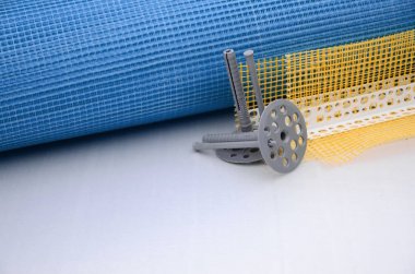 Duvar yalıtım inşaat öğeleri kümesi. Plastik dübeller, bir rulo kafes cepheler ve köşe profili bir kılavuz ile yalıtım için yalan polistren köpük yüzeyinde
