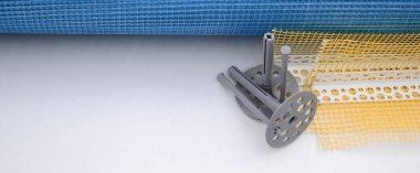 Duvar yalıtım inşaat öğeleri kümesi. Plastik dübeller, bir rulo kafes cepheler ve köşe profili bir kılavuz ile yalıtım için yalan polistren köpük yüzeyinde