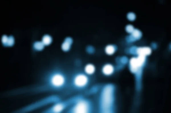 Θολή νυχτερινή σκηνή της κίνησης στο οδόστρωμα. Defocused εικόνα των αυτοκινήτων που ταξιδεύουν με φωτεινές προβολείς. Bokeh τέχνης — Φωτογραφία Αρχείου