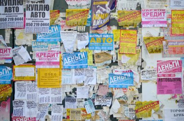 Kharkov, Ukrayna - 2 Ekim 2019: Grunge Mesaj Kurulu birçok reklamla birlikte. İnsanlar beyaz kağıda reklam ve bilgi yayıyorlar, metal çitlere asmaktansa.