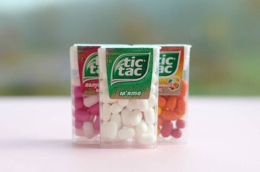 Yeşil ahşap arka planda bir sürü Tic Tac Candy paketi var. Tik tak naneli taze tadı ve taşıması kolay olduğu için popülerdir. 1968 'den beri Ferrero tarafından üretilen nane şekeri.
