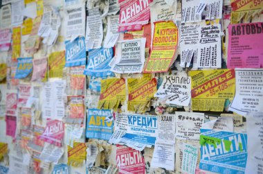 Kharkov, Ukrayna - 2 Ekim 2019: Grunge Mesaj Kurulu birçok reklamla birlikte. İnsanlar beyaz kağıda reklam ve bilgi yayıyorlar, metal çitlere asmaktansa.