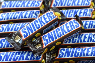Bir sürü Snickers çikolatası üst üste yığılmış. Snickers çikolataları Mars Anonim Şirketi tarafından üretilir. Snickers 1930 yılında Franklin Clarence Mars tarafından yaratıldı.