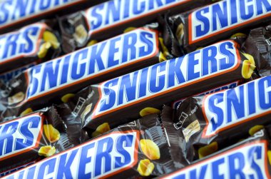 Bir sürü Snickers çikolatası üst üste yığılmış. Snickers çikolataları Mars Anonim Şirketi tarafından üretilir. Snickers 1930 yılında Franklin Clarence Mars tarafından yaratıldı.